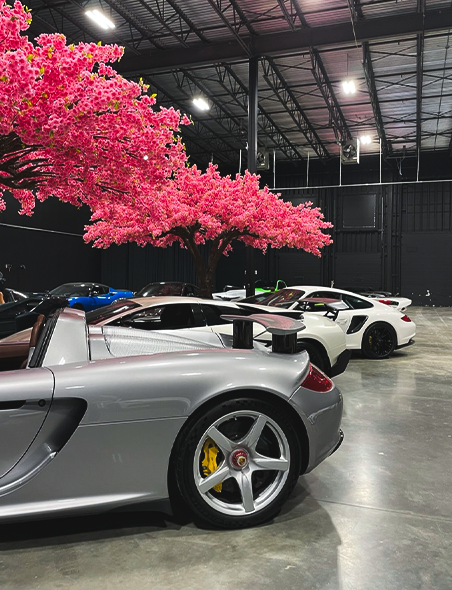 Showroom image of a Porsche Carrera GT, Lamborghini Murcielago SV, and Porsche 911 Turbo in Sigma Automotive.